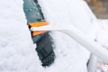 Cleaning car windows from snow with a scraper. Royalty Free Stock Photo