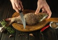 Cleaning carp on a kitchen cutting board with the hands of a chef. Cooking a fish diet in a restaurant kitchen Royalty Free Stock Photo