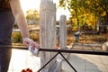 Cleaning cemetery. A woman`s hand washes black fence at grave with rag.