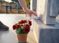 Cleaning cemetery. A woman`s hand washes grey monument at the grave with rag Royalty Free Stock Photo