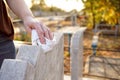 Cleaning cemetery. A woman`s hand washes grey monument at grave with rag. Royalty Free Stock Photo