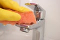 Cleaning chrome faucet with a sponge close up. Royalty Free Stock Photo