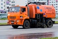 Cleaning of city streets with a special orange watering machine. Royalty Free Stock Photo
