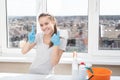 Cleaning company concept. Young girl in rubber gloves smiles, shows a clean finger without dust