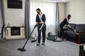 Cleaning company employees remove dirt from furniture in the apartment using professional equipment. Housewife women cleaning sofa