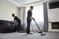 Cleaning company employees remove dirt from furniture in the apartment using professional equipment. Housewife women cleaning sofa