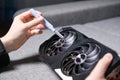 cleaning computer graphics card cooler with soft brush to remove dust from fan blades during pc maintenance Royalty Free Stock Photo