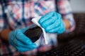 Cleaning a computer mouse device with a disposable antibacterial wipe during coronavirus pandemic emergency using hand sanitizer. Royalty Free Stock Photo