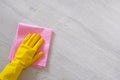 Cleaning concept in office, home. Hand in yellow rubber protective glove with micro fiber cloth is cleaning wooden floor. Copy Royalty Free Stock Photo