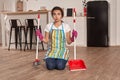 Young woman sweeping floor on the kitchen Royalty Free Stock Photo