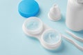 Cleaning contact lenses with solution in case and accessories on blue background Royalty Free Stock Photo