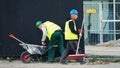 Cleaning debris workers in helmets on construction site