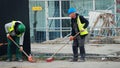 Cleaning debris workers in helmets on construction site