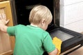 Cleaning dirty oven from grease,food leftovers deposits.Boy child in protective glove,sponge rag washing kitchen stove,helping Royalty Free Stock Photo