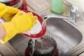 Cleaning dishware kitchen sink sponge washing dish. Close up of female hands in yellow protective rubber gloves washing Royalty Free Stock Photo