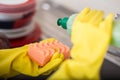 Cleaning dishware kitchen sink sponge washing dish. Close up of female hands in yellow protective rubber gloves washing Royalty Free Stock Photo