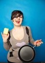 Cleaning dishware kitchen sink sponge washing frying pan. Housewife woman posing on blue studio background with skillet. Royalty Free Stock Photo