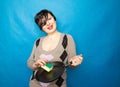 Cleaning dishware kitchen sink sponge washing frying pan. Housewife woman posing on blue studio background with skillet. Royalty Free Stock Photo