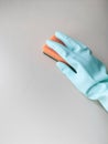 Cleaning and disinfection. A woman in a blue glove holds an orange sponge and washes a light wall Royalty Free Stock Photo