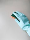 Cleaning and disinfection. A woman in a blue glove holds an orange sponge and washes a light wall Royalty Free Stock Photo