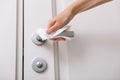 Cleaning door handles with an antiseptic wet wipe and gloves. Woman hand using towel for cleaning home room door link