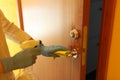 Cleaning door with sanitarizer - woman`s hand in blue medical protective glove with rag wiping door`s handle. care about house.