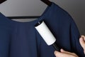 Cleaning the dress with adhesive sticky roller