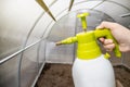 Cleaning the empty greenhouse with an antibacterial cleaner liquid.