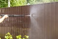 Cleaning fence with high pressure power washer, cleaning dirty wall