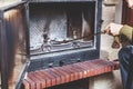 Cleaning fireplace. Hand holding shovel with ash