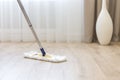 Cleaning floor with white mop near sofa Royalty Free Stock Photo