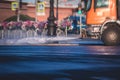 Cleaning flusher sweeper machines washes the city streets road with water spray, group of municipal watering machines wash asphalt