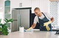 Cleaning is a form of destressing. a young man wiping a surface at home.