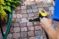 Cleaning the garden cobblestone pathway with a high pressure washer Royalty Free Stock Photo