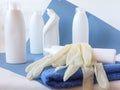 Cleaning gloves on a blue napkin against a background of detergents on a blue background, close-up, side view Royalty Free Stock Photo