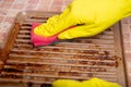 Cleaning the grill. Hands in yellow gloves clean the dirty grill of grease and burns with a cleaning agent. electric grill hygiene