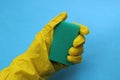 Hand in yellow rubber glove holding a sponge for washing Royalty Free Stock Photo