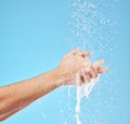 Cleaning hands, water splash and wash for hygiene, healthcare and wellness mockup on a blue studio background. Skin Royalty Free Stock Photo