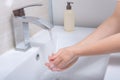Women`s hands close-up under running water in the bathroom above the sink. Hygiene concept Royalty Free Stock Photo