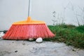 Cleaning home concept, red broom in home garden over green grass