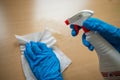 Cleaning home table sanitizing office table surface with disinfectant spray bottle washing surfaces with towel and gloves. COVID- Royalty Free Stock Photo