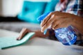 Cleaning home surface with sponge and spray cleaner. Female hands using spray cleaner on white table. Maid wiping dust while