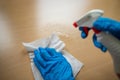 Cleaning home table sanitizing office table surface with disinfectant spray bottle washing surfaces with towel and gloves. COVID- Royalty Free Stock Photo