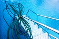 Cleaning hose in the water of a swimming pool, during cleaning work and preparation for the summer bathing season Royalty Free Stock Photo