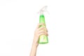 Cleaning the house and cleaner theme: man's hand holding a green spray bottle for cleaning isolated on a white background Royalty Free Stock Photo