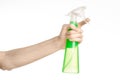 Cleaning the house and cleaner theme: man's hand holding a green spray bottle for cleaning isolated on a white background Royalty Free Stock Photo