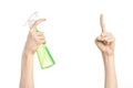 Cleaning the house and cleaner theme: man's hand holding a green spray bottle for cleaning isolated on a white background Royalty Free Stock Photo