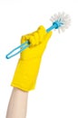 Cleaning the house and cleaning the toilet: human hand holding a blue toilet brush in yellow protective gloves isolated on a white Royalty Free Stock Photo