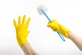 Cleaning the house and cleaning the toilet: human hand holding a blue toilet brush in yellow protective gloves isolated on a white Royalty Free Stock Photo