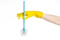 Cleaning the house and cleaning the toilet: human hand holding a blue toilet brush in yellow protective gloves isolated on a white Royalty Free Stock Photo